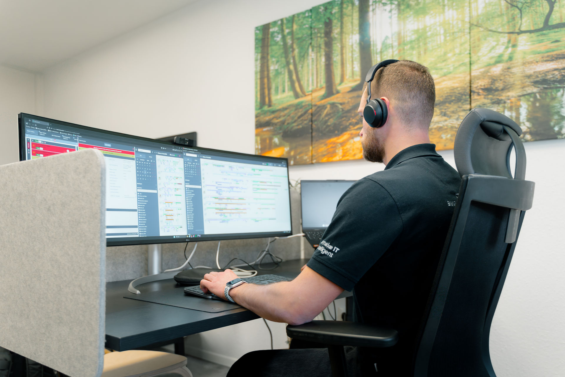 IT-Techniker von BavariaCloud überwacht Unternehmensnetzwerke an zwei Monitoren – IT-Sicherheit für KMU in der Oberpfalz