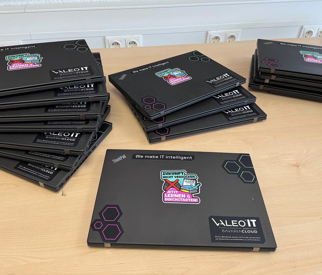 Aufbereitete Lenovo ThinkPad Notebooks mit VALEO IT- und BavariaCloud-Branding und Sticker "Zukunft nicht verzocken. Jetzt lernen und durchstarten!" für die Notebook-Spendenaktion an Grundschulen