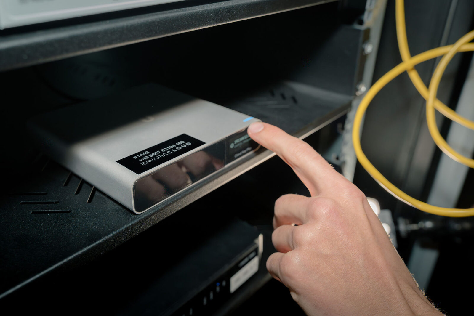 Techniker schaltet ein Netzwerkgerät im Serverschrank ein