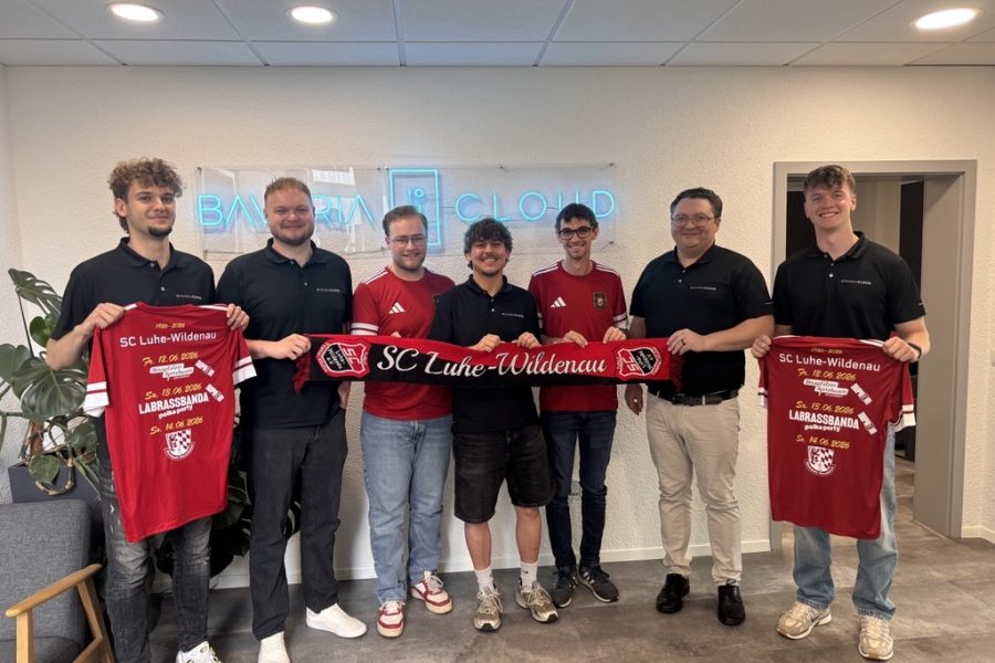 BavariaCloud-Team und SC Luhe-Wildenau gemeinsam im Büro in Oberwildenau mit Vereinsschal und Jubiläums-Trikots zum 100-jährigen Vereinsjubiläum